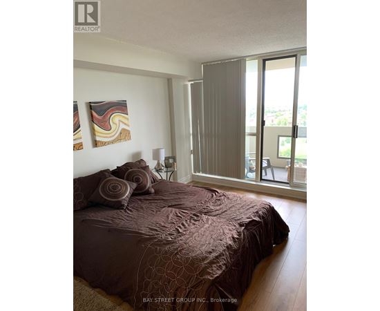 A bedroom with a large bed and a painting on the wall.