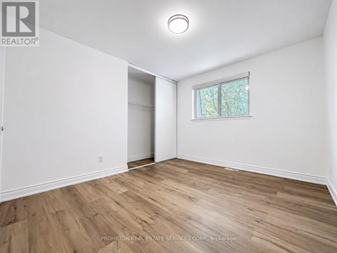 A room with a window and wooden flooring.