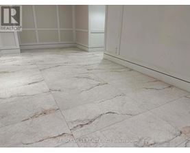 A marble tiled floor in a room with a brokerage logo.