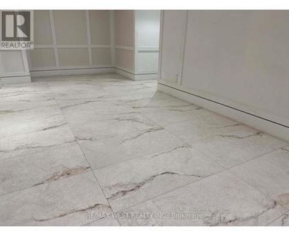 A marble tiled floor in a room with a brokerage logo.