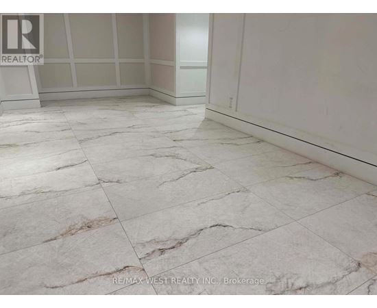A marble tiled floor in a room with a brokerage logo.
