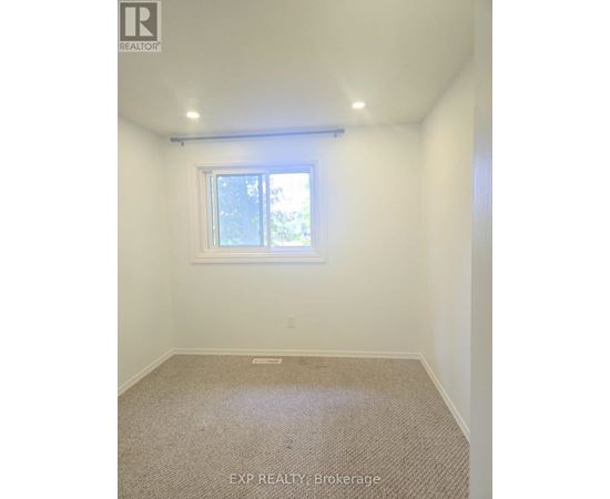 A room with a window and carpeted floor.