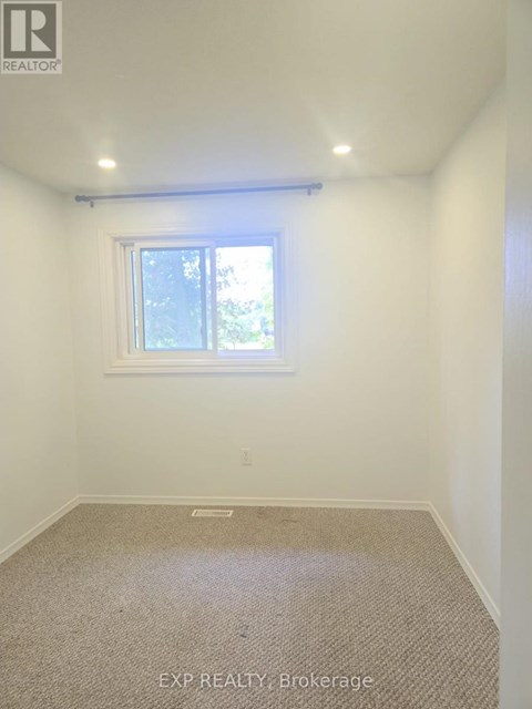 A room with a window and carpeted floor.