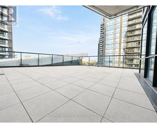 A rooftop terrace with a tiled floor and a glass railing.