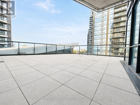 A rooftop terrace with a tiled floor and a glass railing.