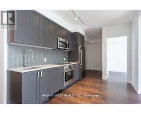 A kitchen with dark grey cabinets and a white countertop.