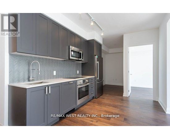 A kitchen with dark grey cabinets and a white countertop.