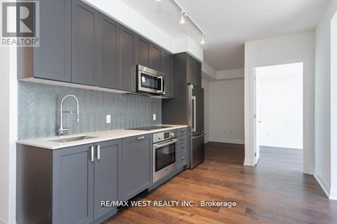 A kitchen with dark grey cabinets and a white countertop.