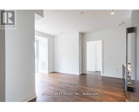 A spacious room with wooden flooring and white walls, brokerage by RE/MAX West Realty Inc.