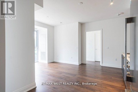A spacious room with wooden flooring and white walls, brokerage by RE/MAX West Realty Inc.