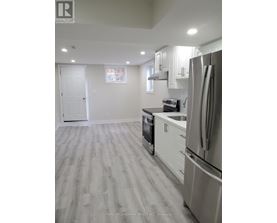 A kitchen with a refrigerator, oven, and cabinets.