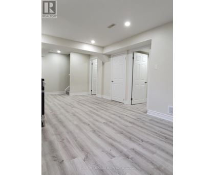 A room with white walls and a wooden floor.