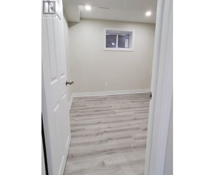 A hallway with wooden flooring and white walls.