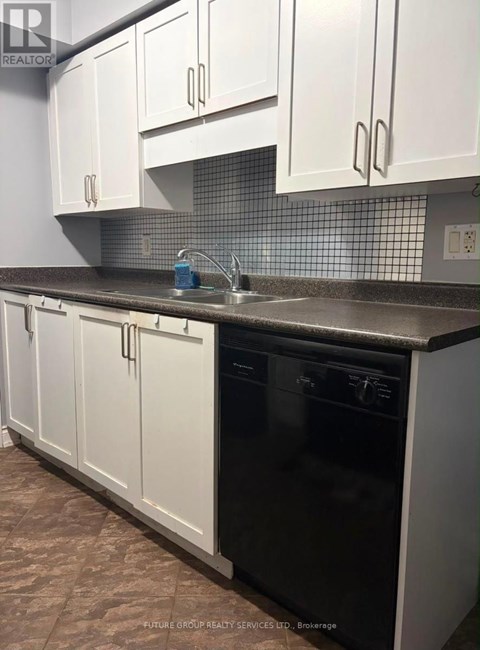 A kitchen with white cabinets and a black dishwasher.