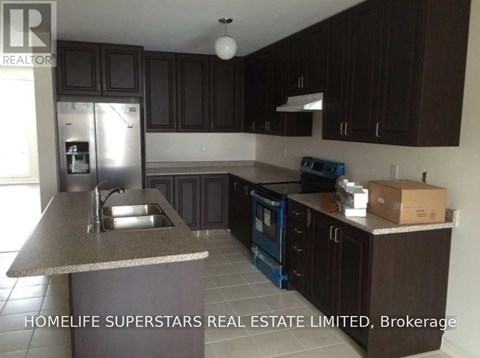A kitchen with dark brown cabinets and a granite countertop.