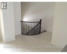 A room with a black railing and a grey carpet.