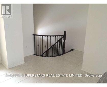 A room with a black railing and a grey carpet.