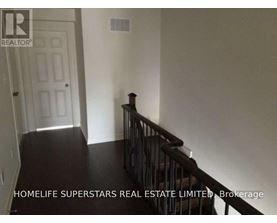A hallway with a staircase leading to the second floor.