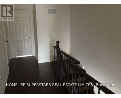 A hallway with a staircase leading to the second floor.