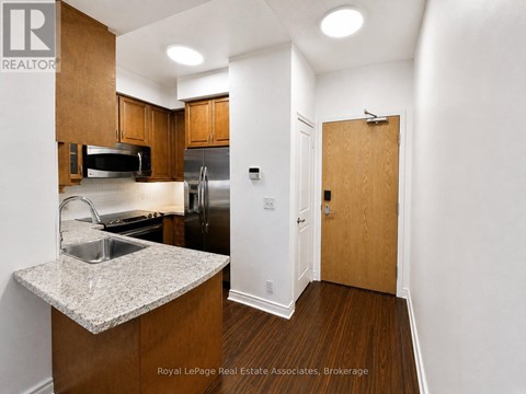 A kitchen with wooden cabinets and a sink.