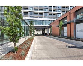 A long walkway with a tree on the left and a building on the right.