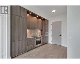 A modern kitchen with wooden cabinets and a built-in oven.