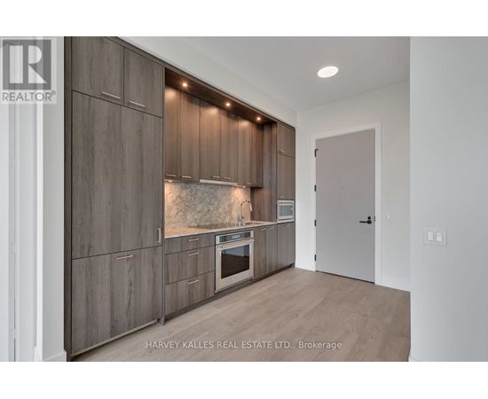 A modern kitchen with wooden cabinets and a built-in oven.