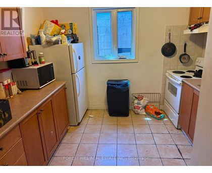 A kitchen with a refrigerator, microwave, and oven.