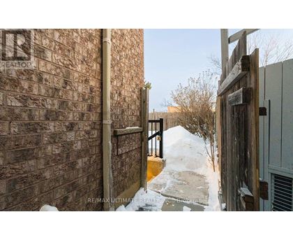 A snow-covered pathway leads to a wooden gate.