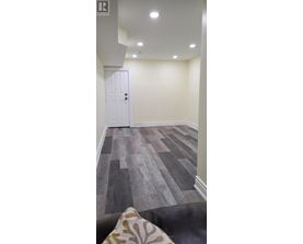 A room with a white door and a wooden floor.