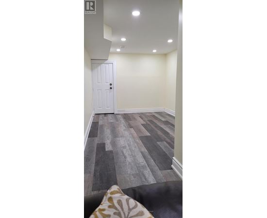 A room with a white door and a wooden floor.