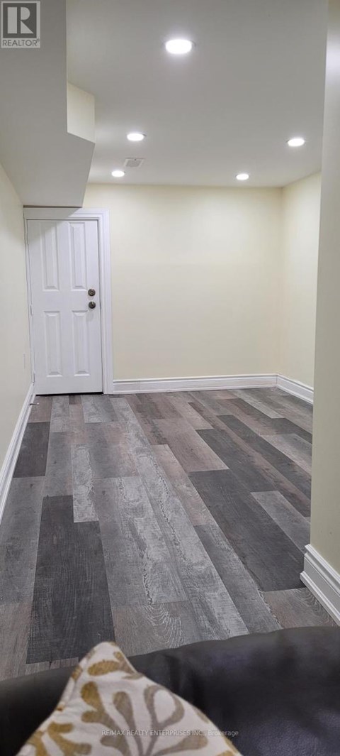 A room with a white door and a wooden floor.