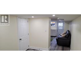 A white door is in a hallway with a couch and a chair.