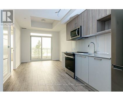 A modern kitchen with white cabinets and a microwave above the oven.
