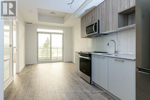 A modern kitchen with white cabinets and a microwave above the oven.