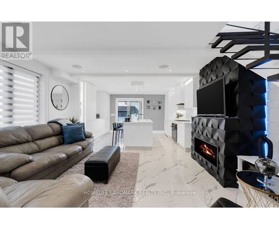 A modern living room with a black leather couch and a fireplace.