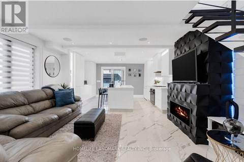 A modern living room with a black leather couch and a fireplace.