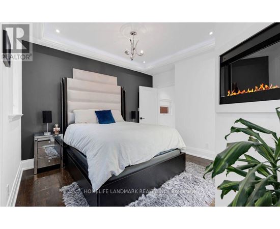 A bedroom with a large bed and a fireplace.