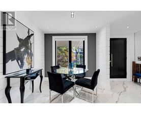 A modern dining room with a glass table and black chairs.