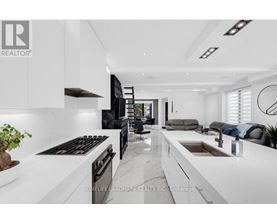 A modern kitchen with white cabinets and a black stove top oven.