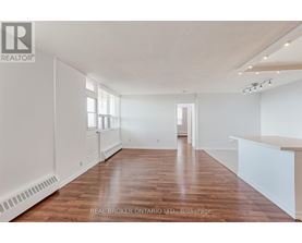 A spacious room with wooden floors and white walls.