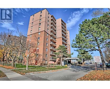 A tall brick apartment building with a sign that says "REAL BROKER ONTARIO LTD, Brokerage" in front of it.