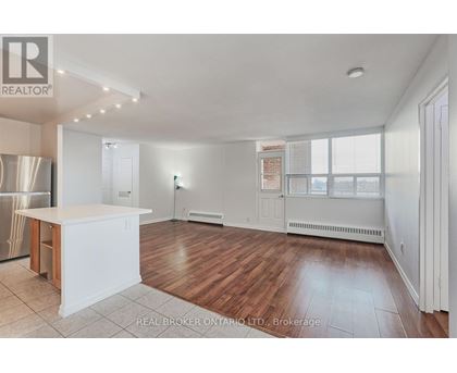 A spacious kitchen with white cabinets and a wooden island.