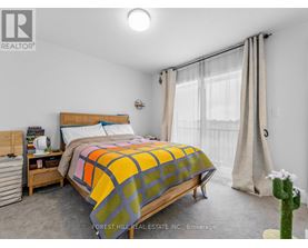 A bedroom with a bed, nightstand, and window.
