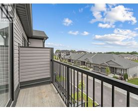 A balcony view of a residential area with houses and trees.