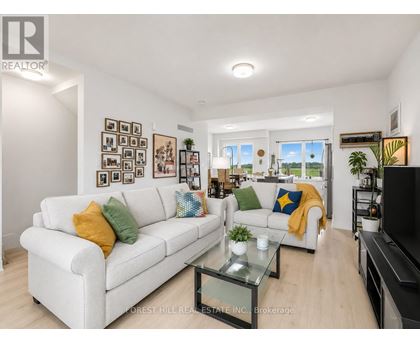 A living room with a white couch and a glass coffee table.