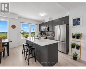 A kitchen with a refrigerator, microwave, and stove top oven.