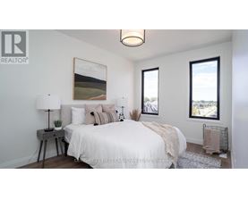 A bedroom with a bed, nightstand, and a painting on the wall.