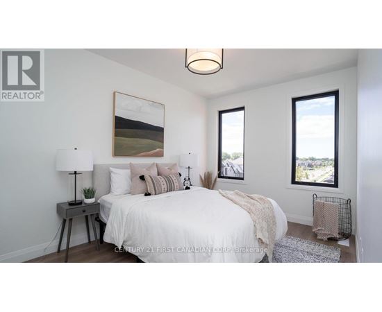 A bedroom with a bed, nightstand, and a painting on the wall.