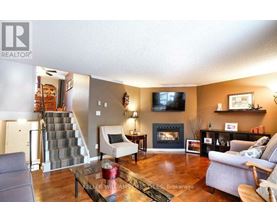 A living room with a grey couch, a coffee table, a fireplace, and a television.